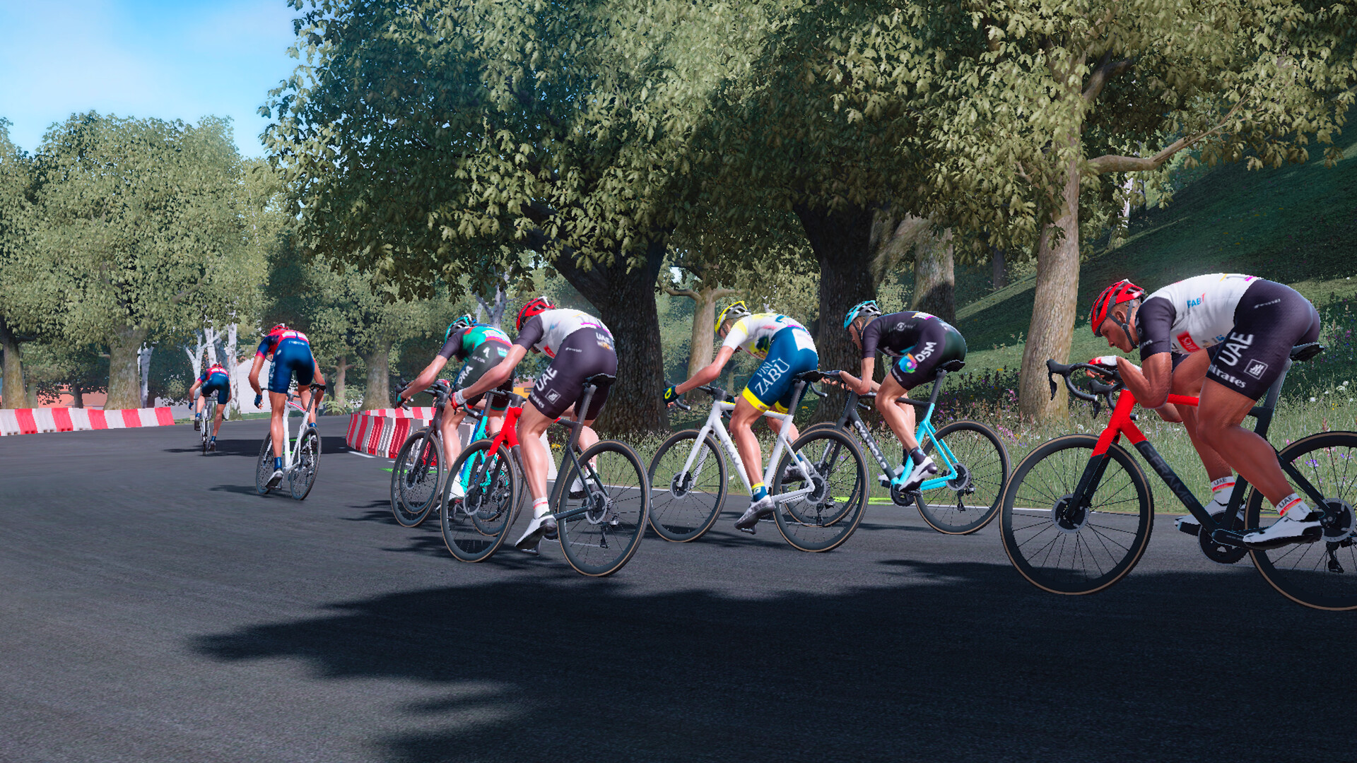 A screenshot of Tour de France 2023. A group of riders are about to take a curve with no UI elements on screen.